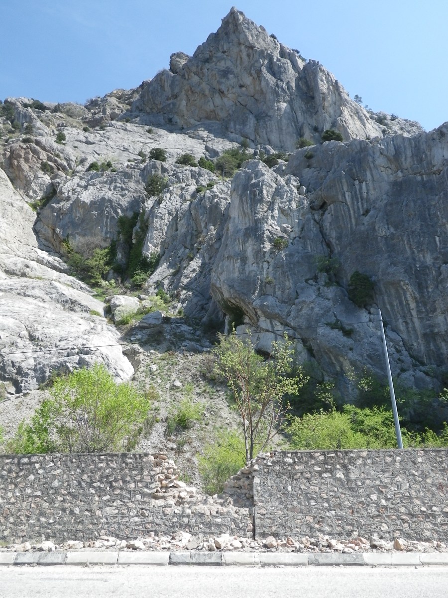 Скала с которой упал героический камень и разрушенная им бутовая стена