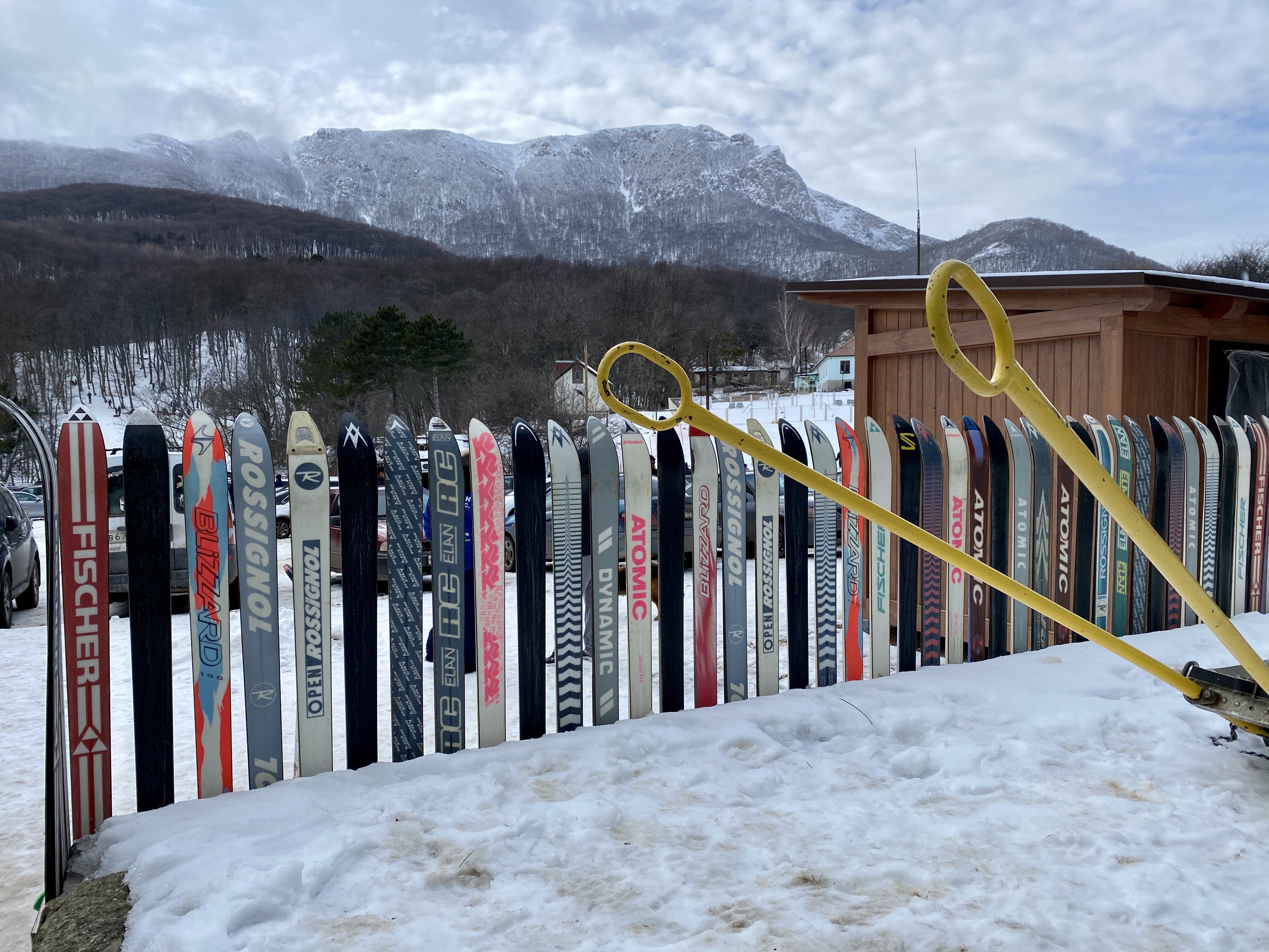 За забором виден склон Чатыр-Дага с его кулуарами и горнолыжной трассой